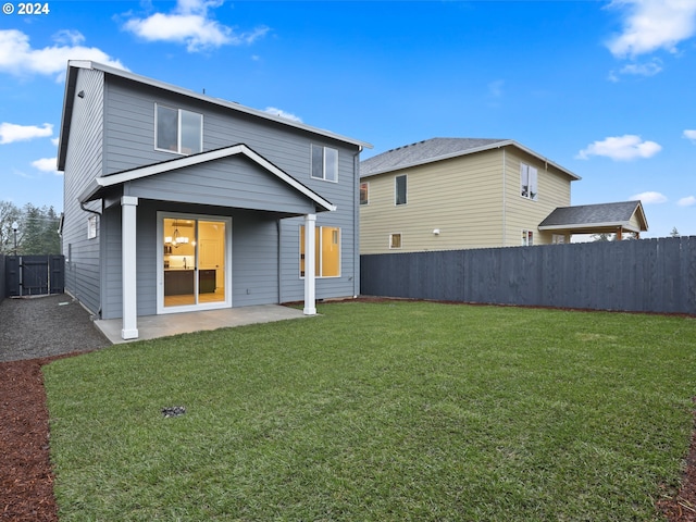 rear view of property featuring a patio area and a lawn