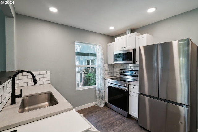 kitchen featuring stainless steel appliances, white cabinetry, a sink, and dark wood-style floors