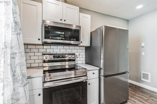 kitchen with appliances with stainless steel finishes, light countertops, and white cabinetry