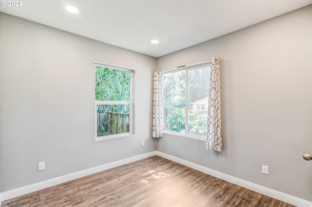 unfurnished room with recessed lighting, baseboards, and wood finished floors