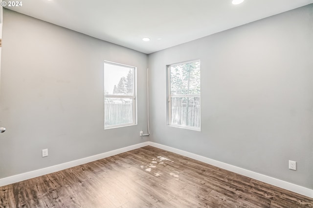 unfurnished room featuring recessed lighting, baseboards, and wood finished floors