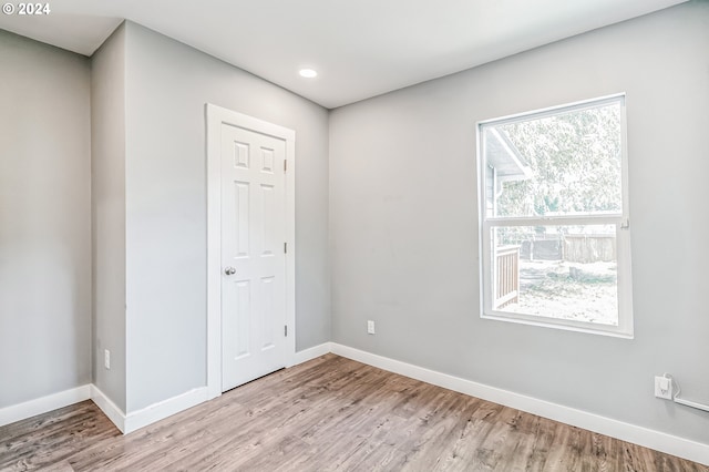 spare room featuring light wood-style floors and baseboards