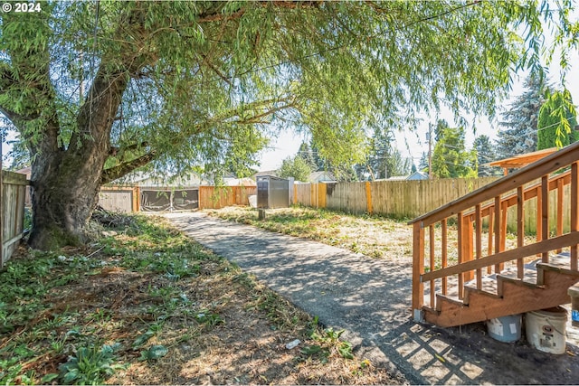 view of yard featuring a fenced backyard, a storage unit, and an outbuilding