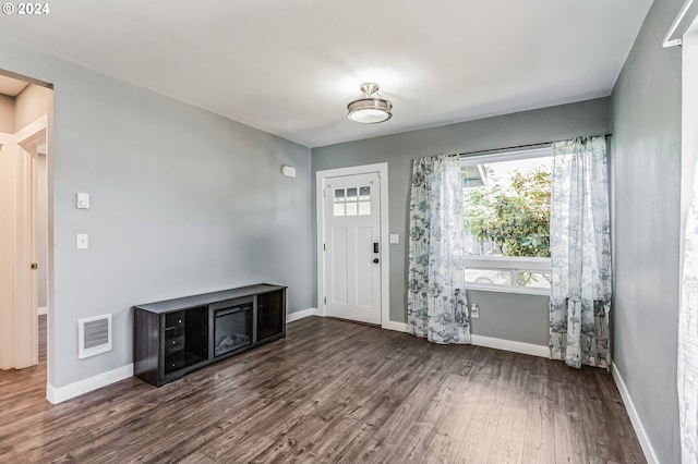 foyer entrance featuring baseboards, visible vents, and dark wood-type flooring