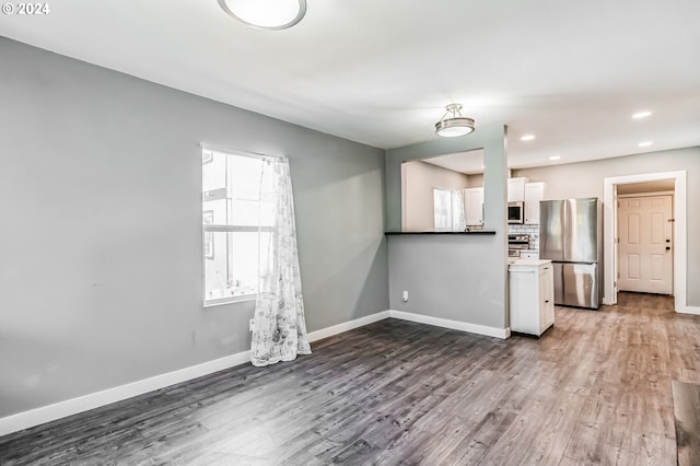 kitchen with dark wood-type flooring, white cabinetry, baseboards, light countertops, and appliances with stainless steel finishes