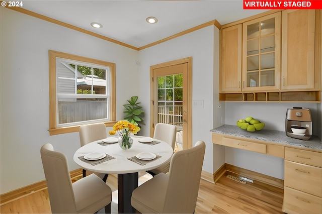 dining area with light hardwood / wood-style floors and ornamental molding