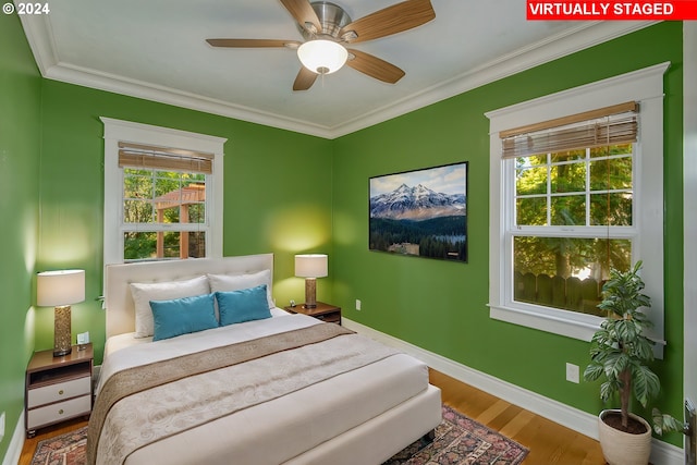 bedroom with ornamental molding, ceiling fan, and hardwood / wood-style floors