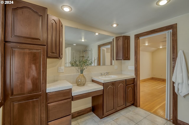 bathroom featuring tile patterned flooring, a shower with shower door, and vanity