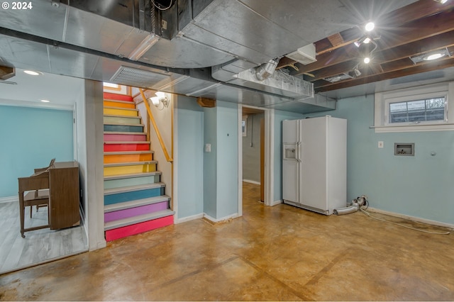 basement featuring white fridge with ice dispenser