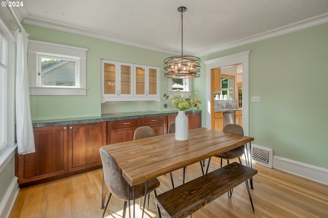 dining room featuring light hardwood / wood-style flooring, a chandelier, and ornamental molding