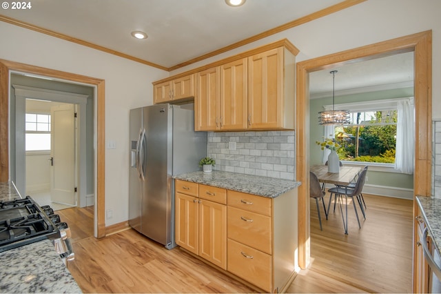 kitchen featuring appliances with stainless steel finishes, tasteful backsplash, light stone countertops, light hardwood / wood-style flooring, and a notable chandelier