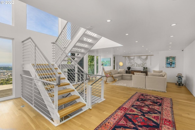 stairs featuring a wealth of natural light and hardwood / wood-style floors