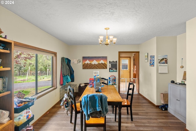 dining area featuring an inviting chandelier, a textured ceiling, and wood-type flooring