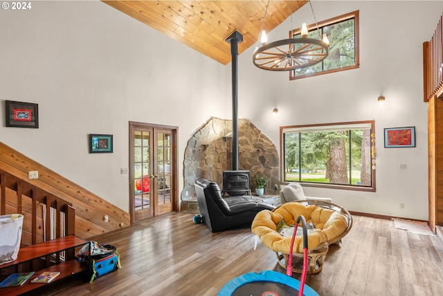 game room with a wood stove, wood-type flooring, high vaulted ceiling, and wooden ceiling