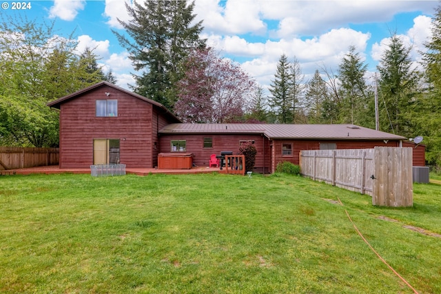 rear view of property with a lawn and central AC unit