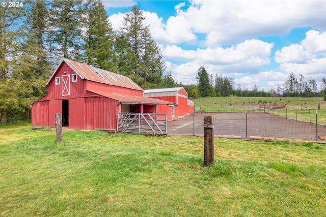 view of outbuilding with a lawn and a rural view