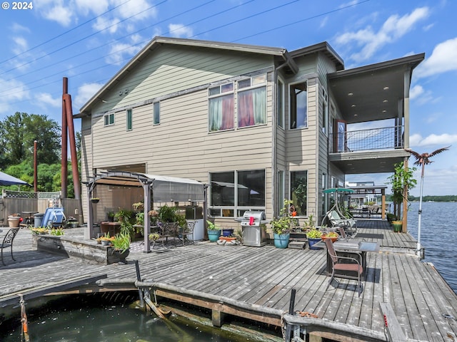 back of house featuring a gazebo, a water view, and a balcony