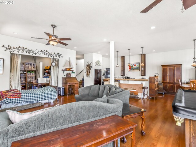 living room featuring dark wood-type flooring and ceiling fan