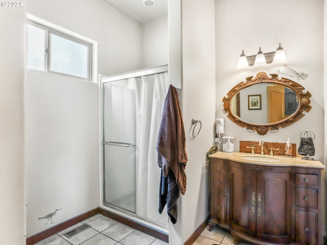 bathroom with a shower with shower door, vanity, and tile patterned flooring