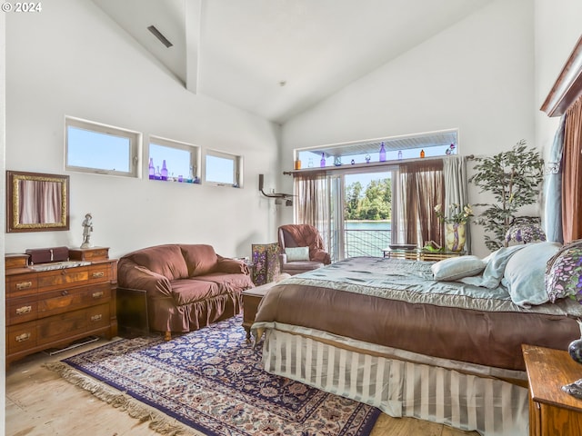 bedroom with light hardwood / wood-style floors, access to exterior, and high vaulted ceiling