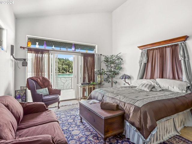 bedroom with carpet floors, access to exterior, and high vaulted ceiling