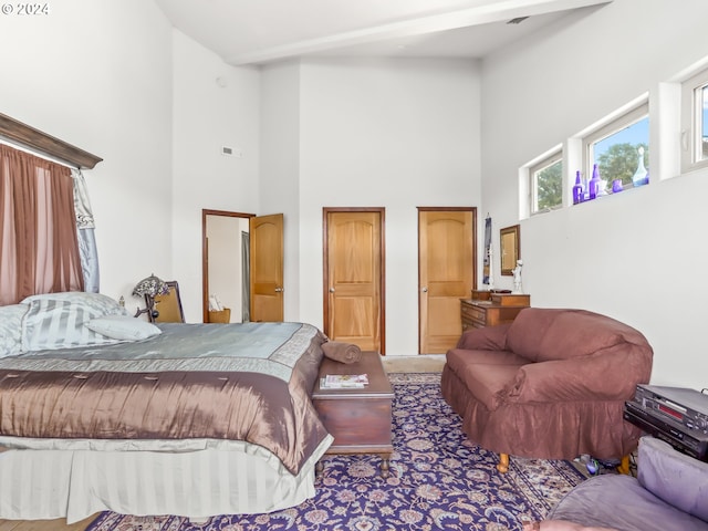 carpeted bedroom featuring a towering ceiling