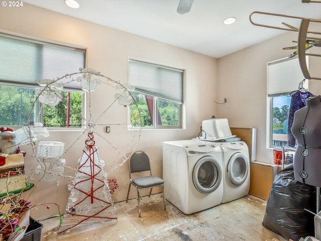 clothes washing area with hardwood / wood-style flooring, washing machine and dryer, and ceiling fan