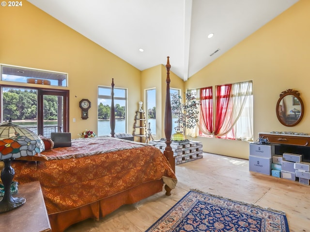 bedroom with a water view, access to outside, and high vaulted ceiling