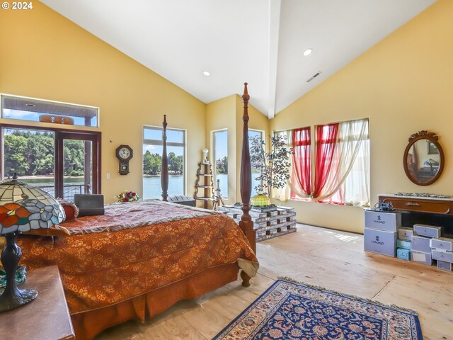 bedroom with access to outside, high vaulted ceiling, and a water view