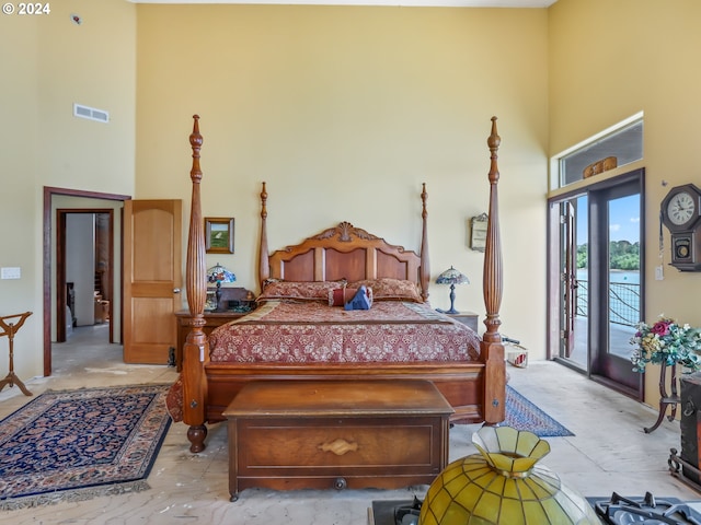 bedroom with a towering ceiling and access to outside