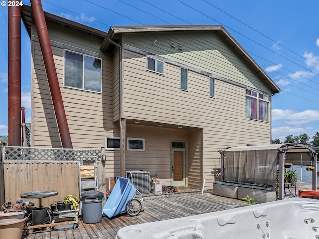 back of property featuring a deck and central AC