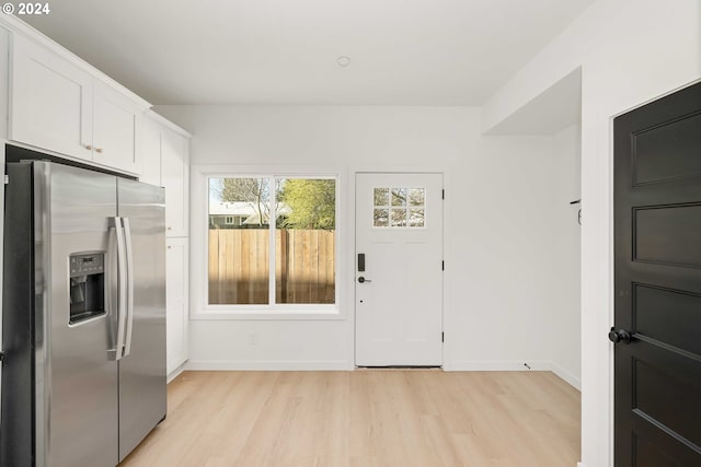 6061 NE Simpson St, Portland, OR 97218 - kitchen with stainless steel fridge with ice dispenser, light wood-style flooring, and white cabinets