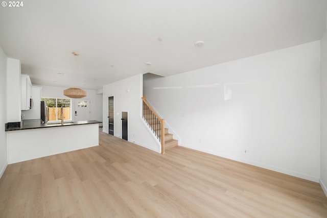 6061 NE Simpson St, Portland, OR 97218 - unfurnished living room with stairs and light wood finished floors