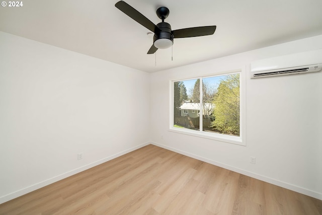 empty room featuring light hardwood / wood-style floors, a wall mounted AC, and ceiling fan