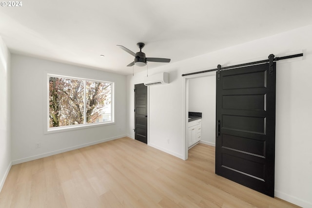6061 NE Simpson St, Portland, OR 97218 - unfurnished bedroom featuring a barn door, light wood-style flooring, a wall mounted air conditioner, and ceiling fan