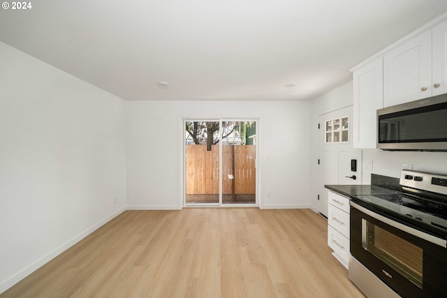 6061 NE Simpson St, Portland, OR 97218 - kitchen featuring appliances with stainless steel finishes, light wood-style floors, and white cabinetry