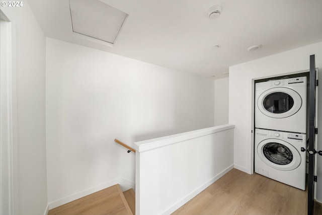 6061 NE Simpson St, Portland, OR 97218 - laundry area featuring stacked washing machine and dryer, light wood finished floors, and attic access
