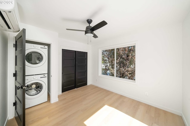 6061 NE Simpson St, Portland, OR 97218 - laundry area with stacked washer / drying machine, a wall mounted AC, ceiling fan, and wood finished floors