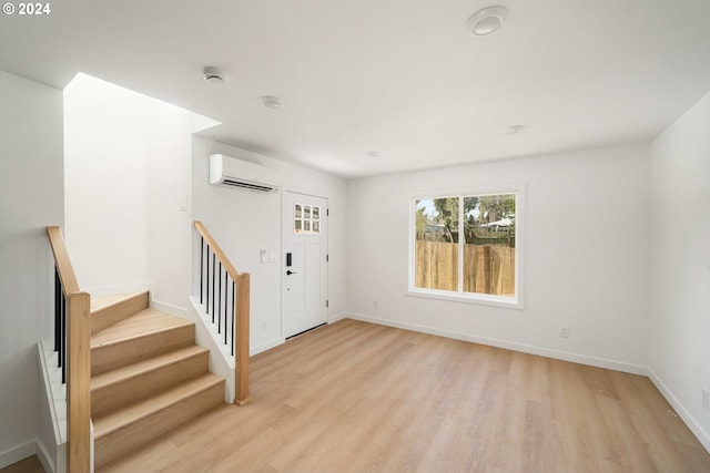 6061 NE Simpson St, Portland, OR 97218 - foyer with a wall unit AC, light wood-style flooring, and stairway