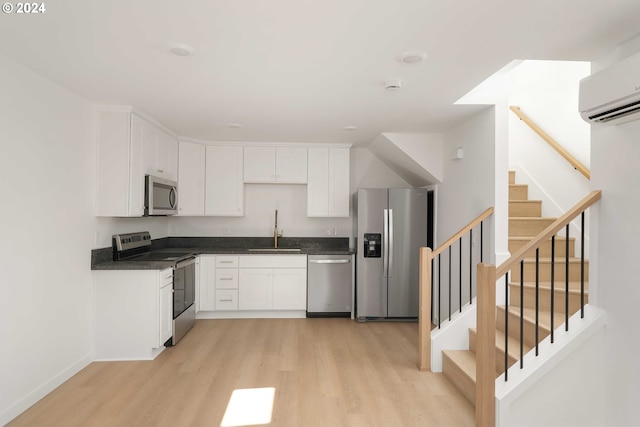 6061 NE Simpson St, Portland, OR 97218 - kitchen with appliances with stainless steel finishes, light wood-style floors, dark countertops, and white cabinetry