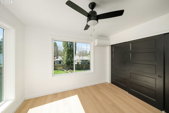 6061 NE Simpson St, Portland, OR 97218 - unfurnished bedroom featuring an AC wall unit, light wood-style floors, and ceiling fan