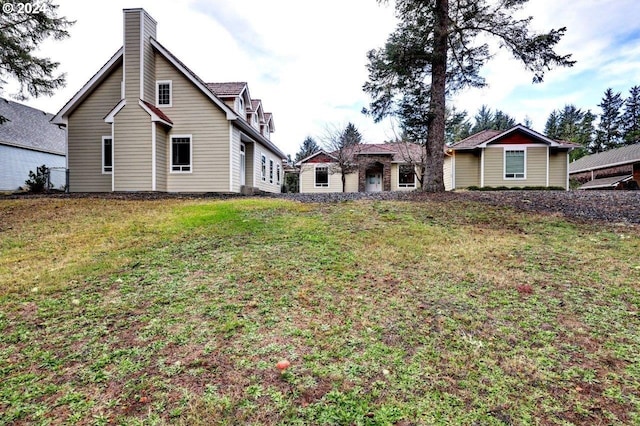 rear view of property featuring a yard