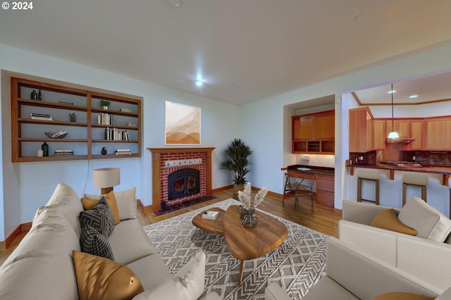 living room with hardwood / wood-style floors and a brick fireplace