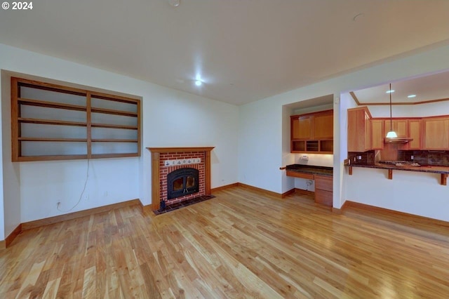 unfurnished living room featuring a fireplace and light hardwood / wood-style flooring