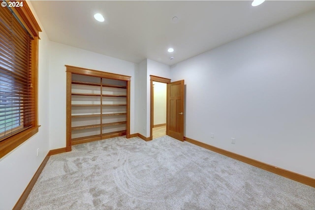 unfurnished bedroom featuring a closet and light colored carpet