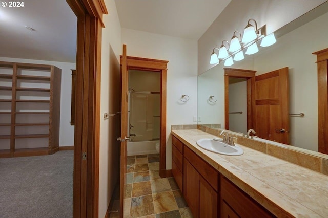 full bathroom featuring vanity, toilet, and shower / bath combination with glass door