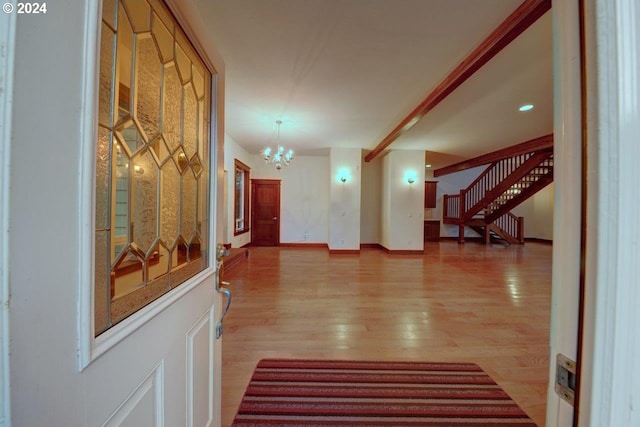 corridor with a notable chandelier, light hardwood / wood-style floors, and radiator heating unit