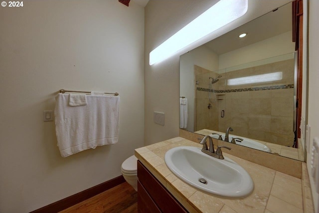 bathroom featuring vanity, hardwood / wood-style flooring, toilet, and an enclosed shower