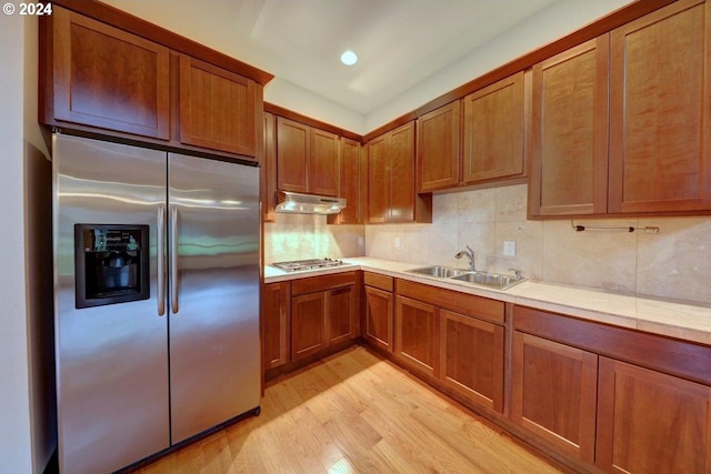 kitchen featuring decorative backsplash, stainless steel appliances, light hardwood / wood-style flooring, and sink