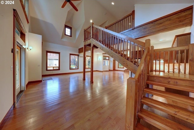 living room with ceiling fan, high vaulted ceiling, and light hardwood / wood-style flooring